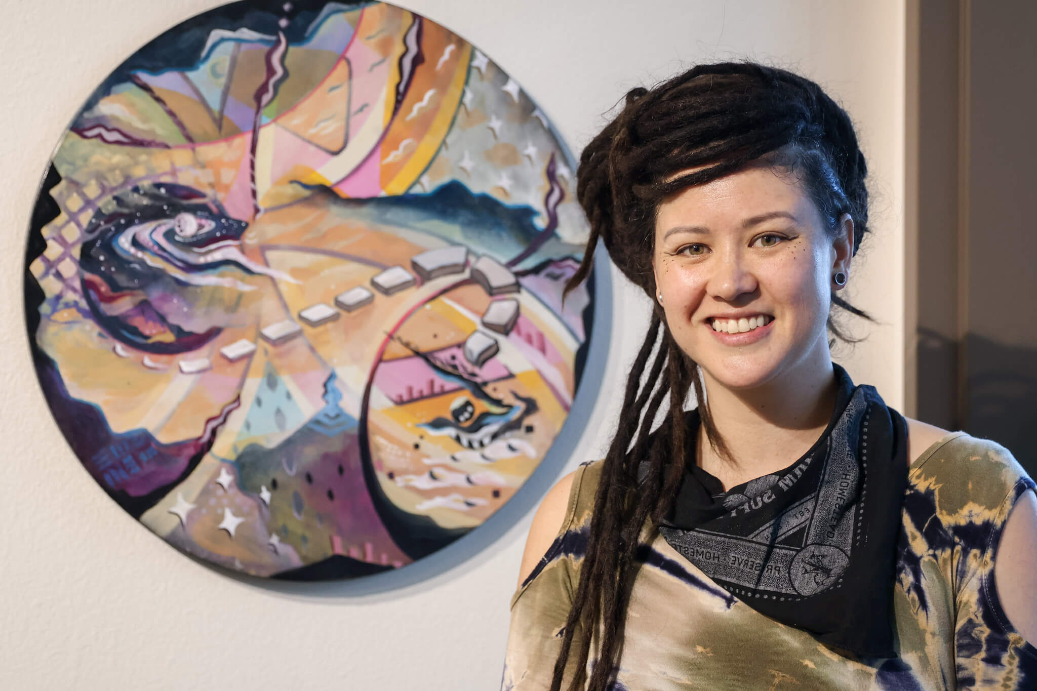 Artist standing by artwork