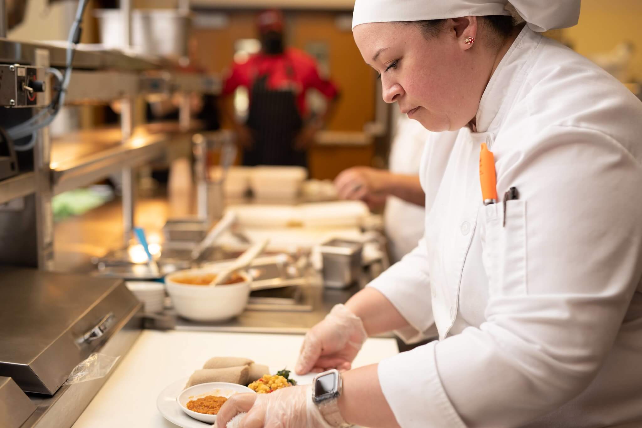 Hospitality Management student prepping plate for service