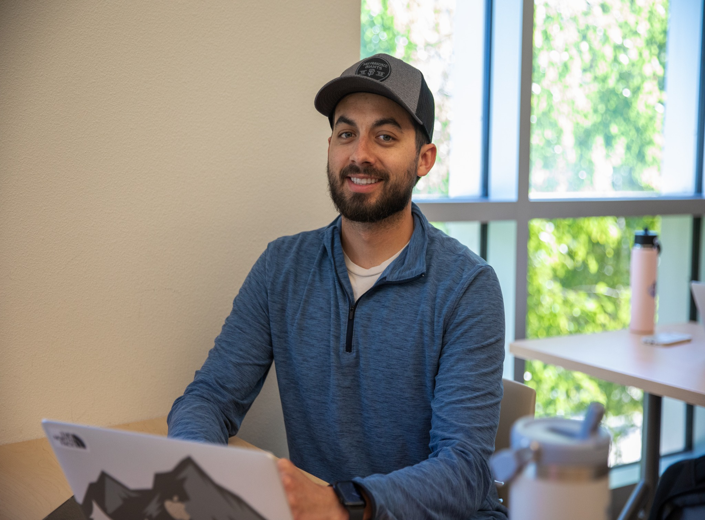 Young man with dark beard and hat attends a Nursing course at Mission College.