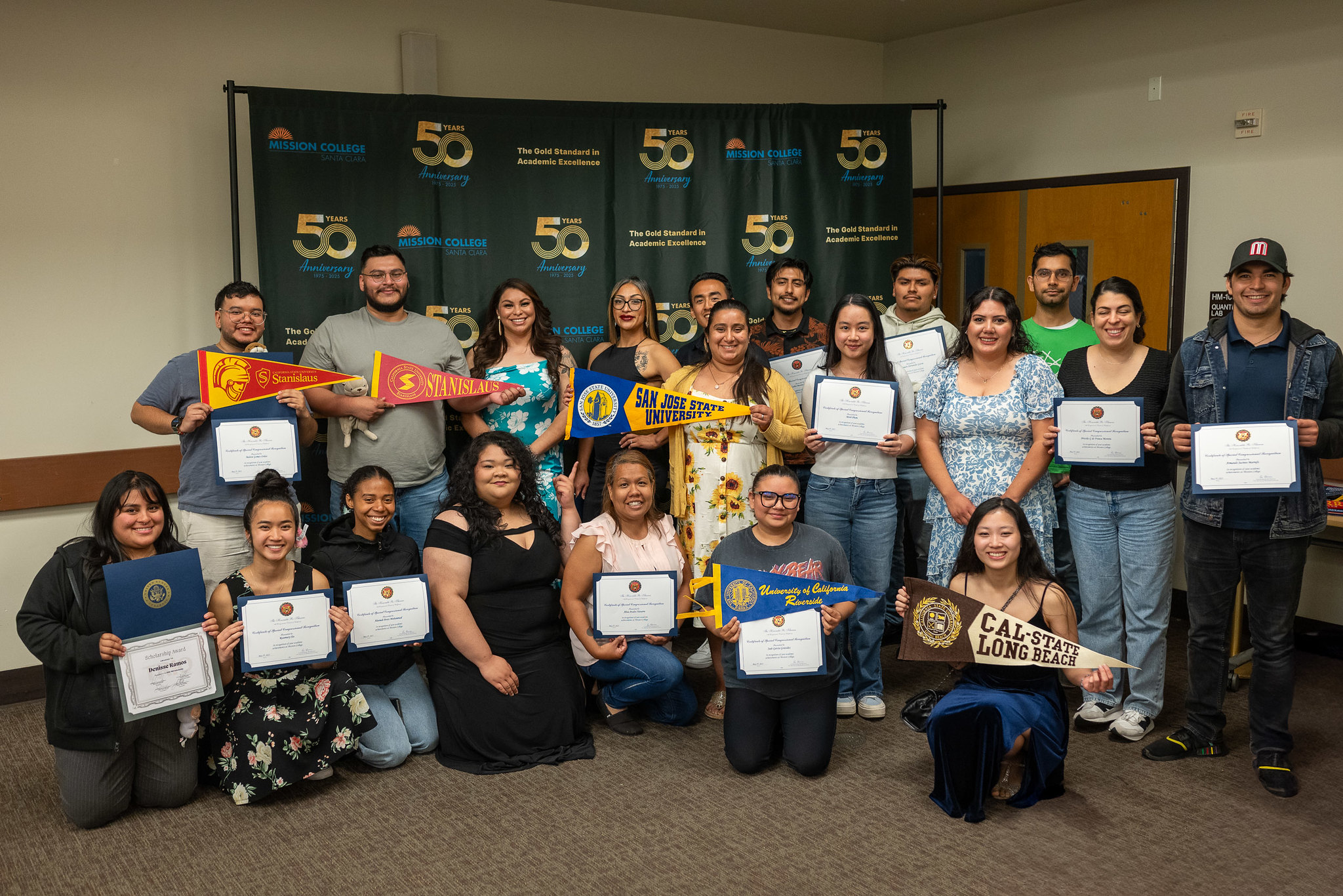 Students posing for picture holding transfer college banners