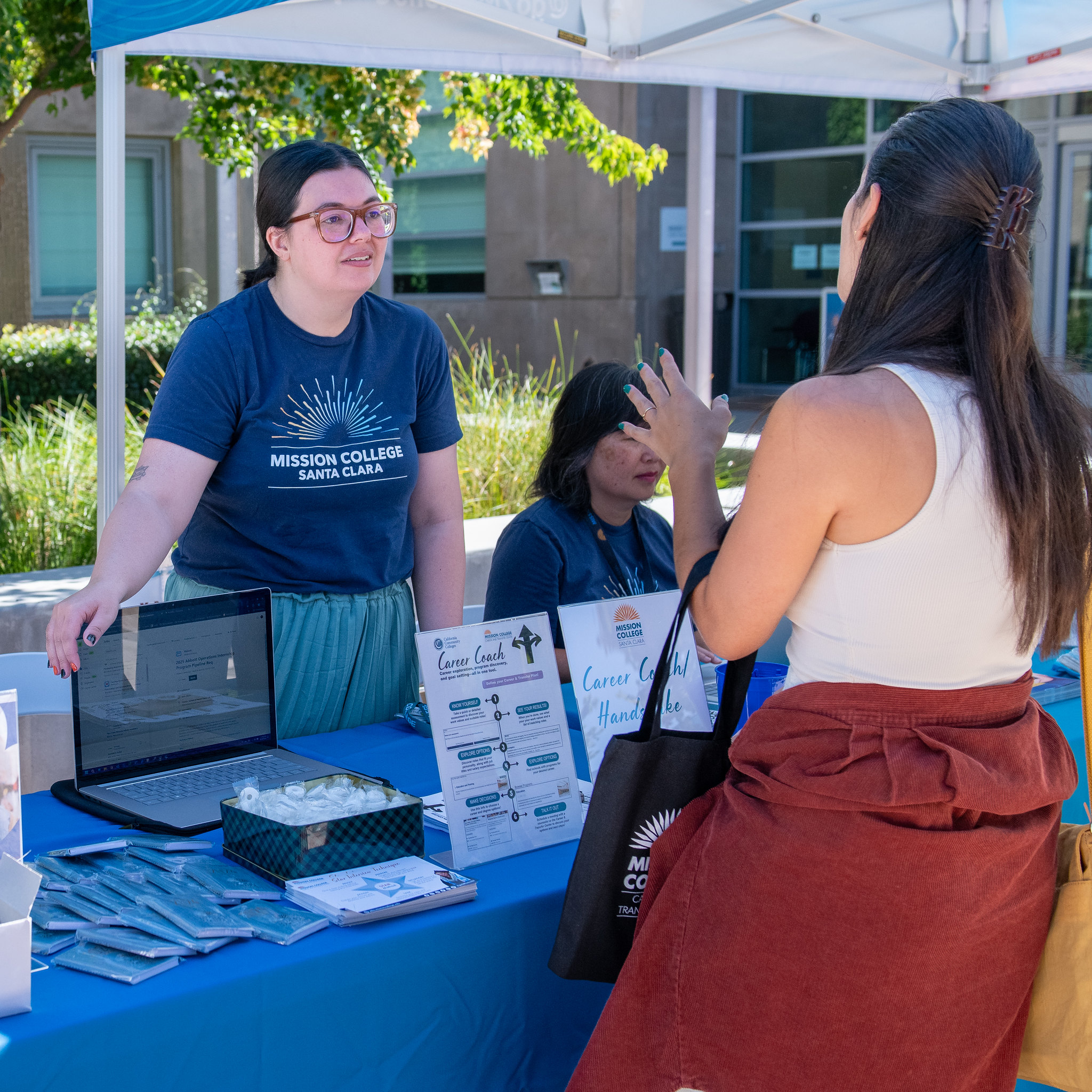 Mission College student talking to someone behind a table