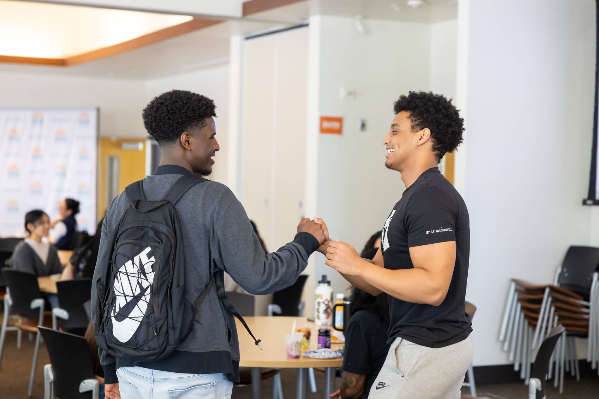 Two male students greeting each other