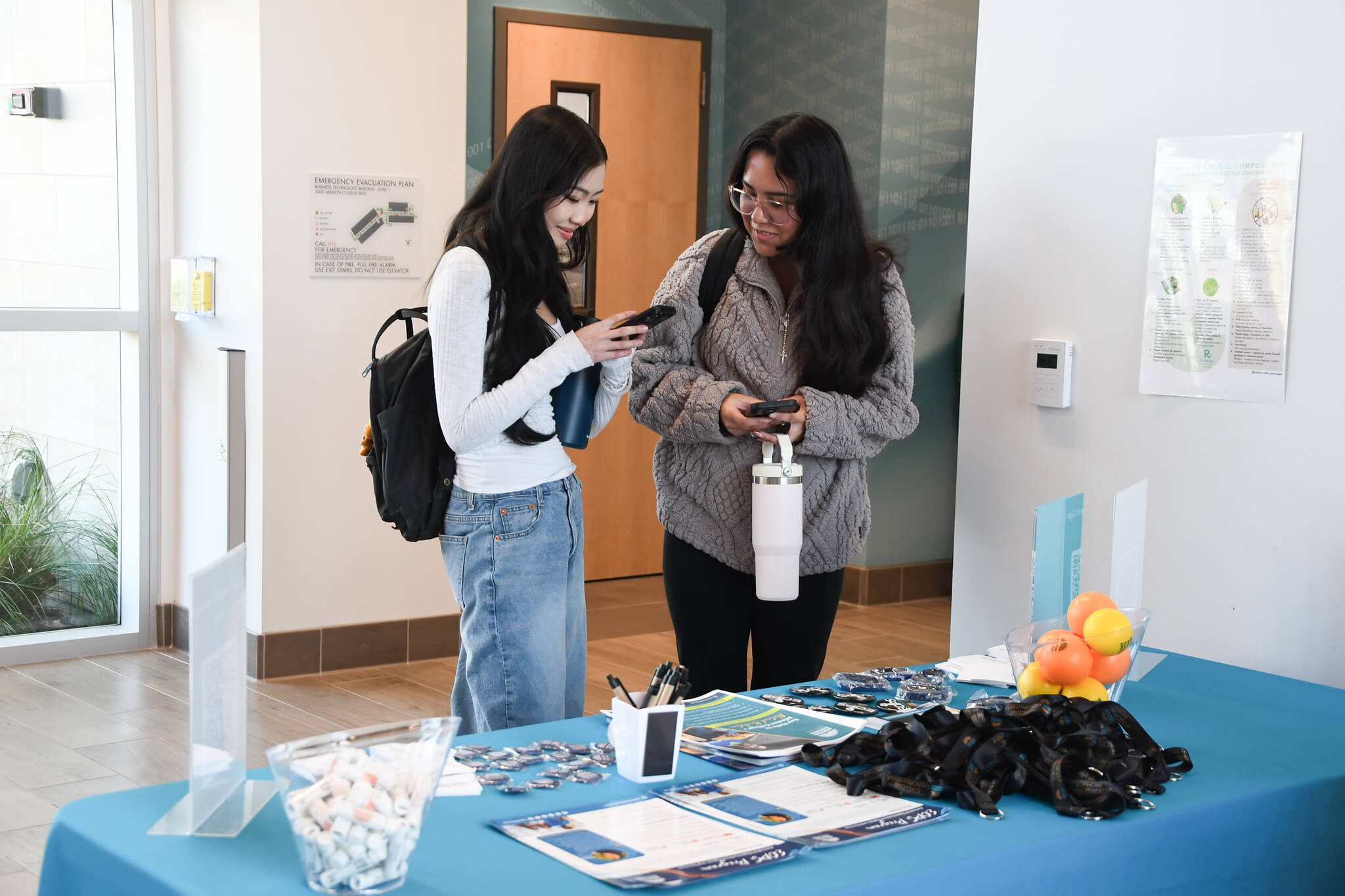 Two female students looking at their phones