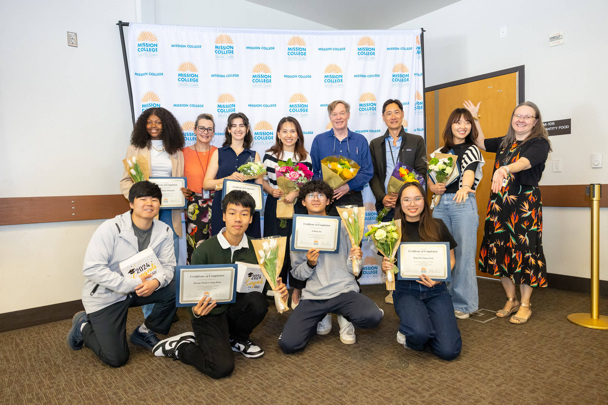 Internation Students holding their certificates at a graduation luncheon
