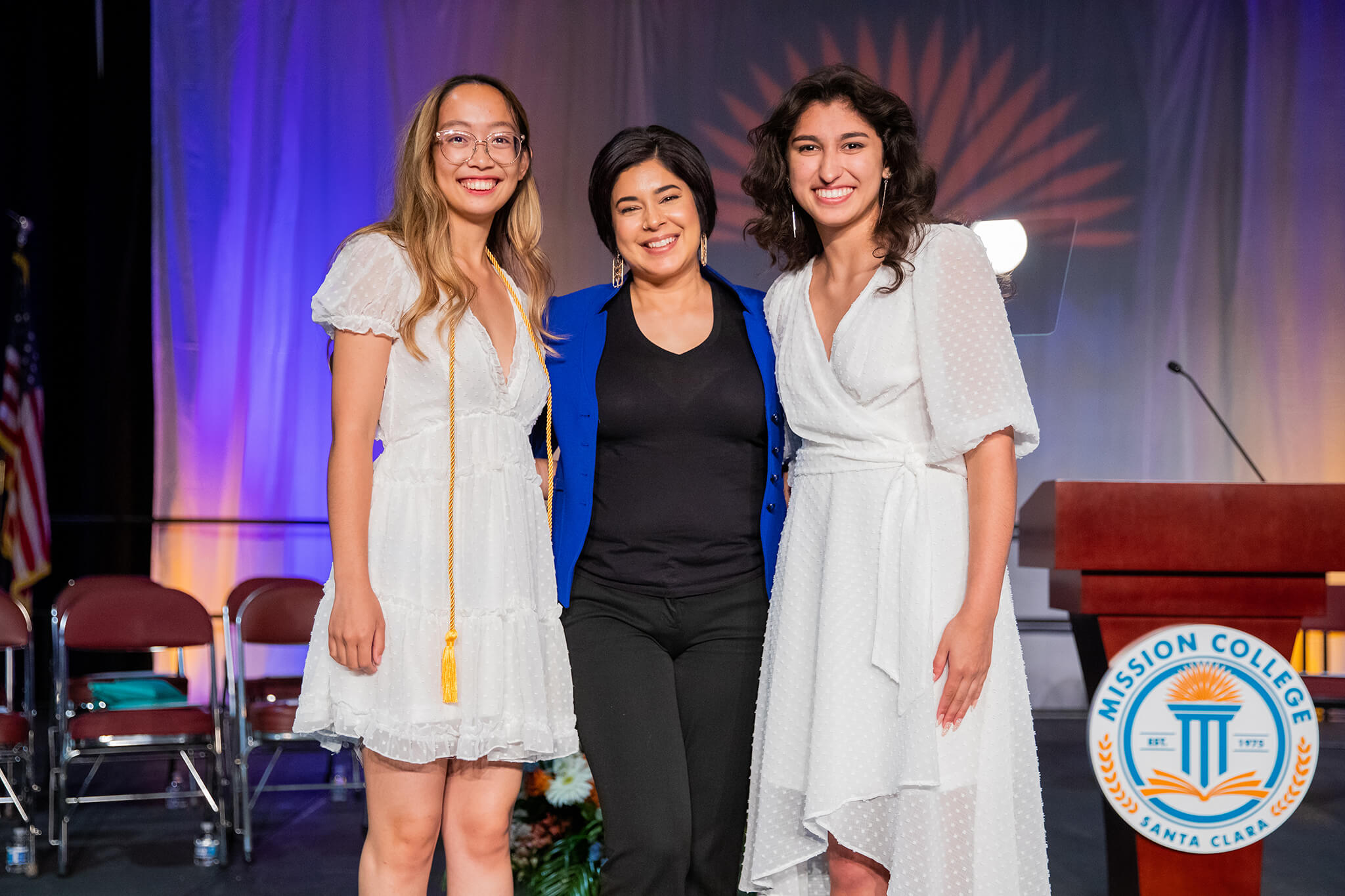 Seher posing at commencement with two female students