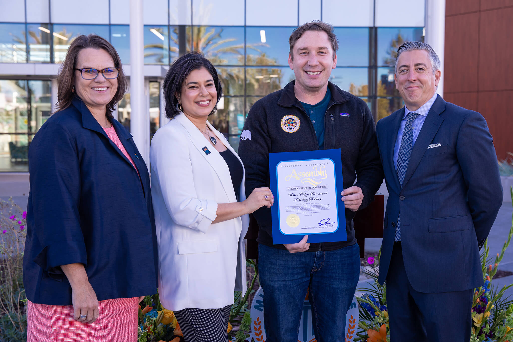 Seher Awan and faculty giving a certificate to a student