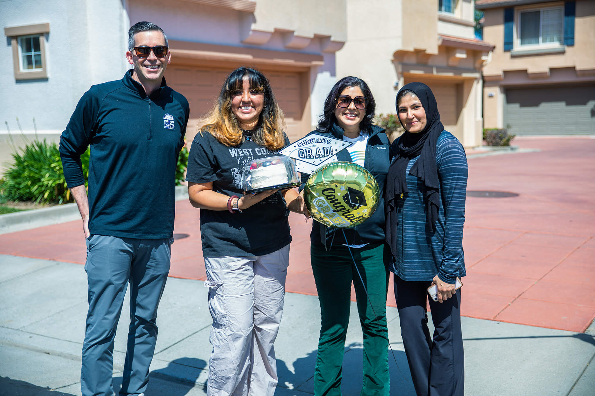 Seher Awan posing for picture outside with graduate and faculty members