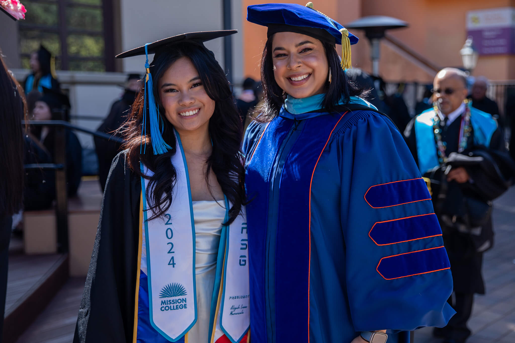 Seher Awan posing for picture with Mission College graduate in commencement robes