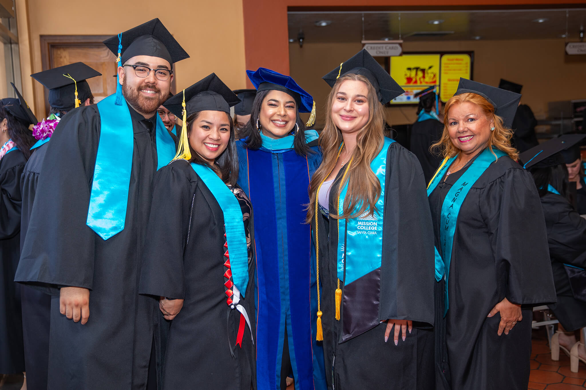 Seher Awan posing for picture with Mission College graduates in commencement robes