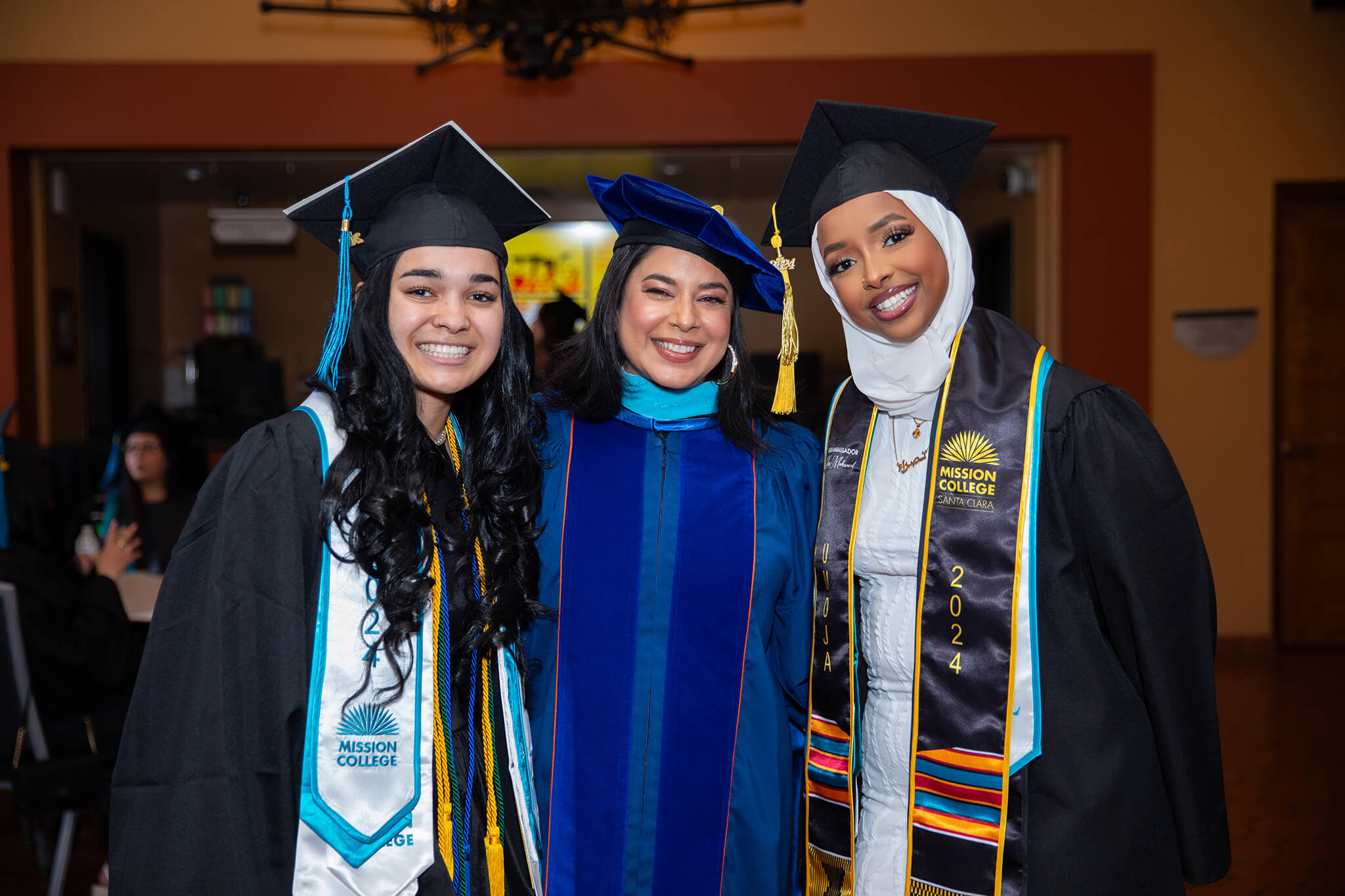Seher Awan posing for picture with Mission College graduates in commencement robes
