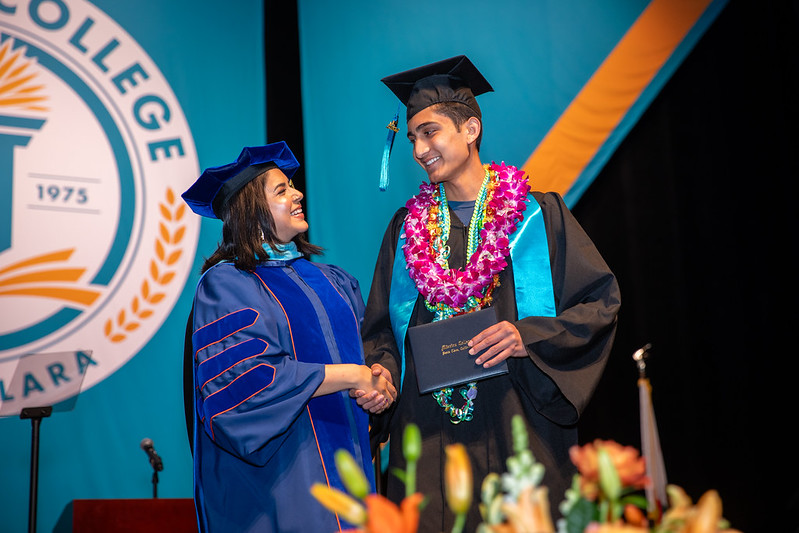 Dr. Awan shaking students hand at commencement
