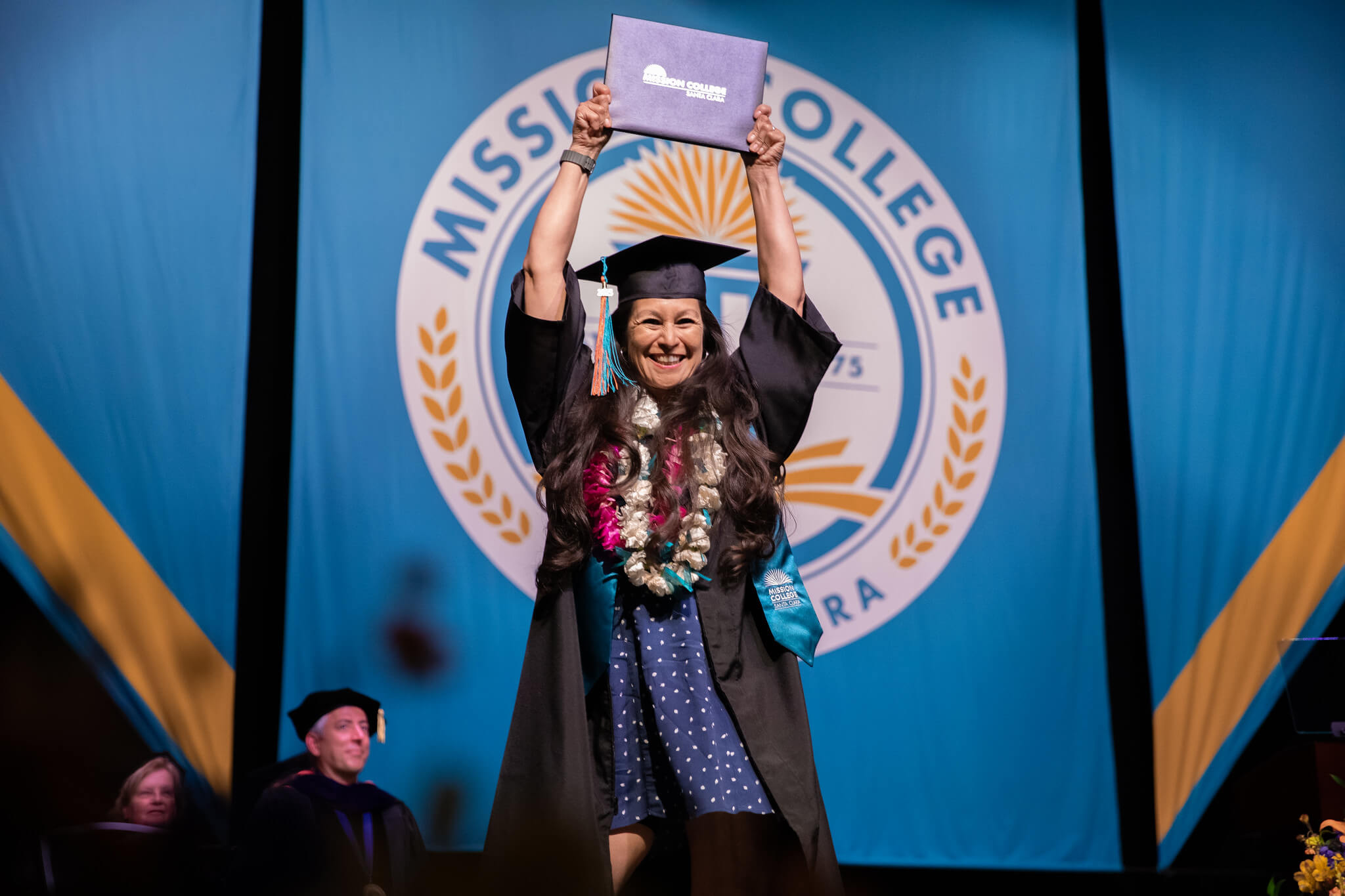 Mission College graduate holding up her certificate