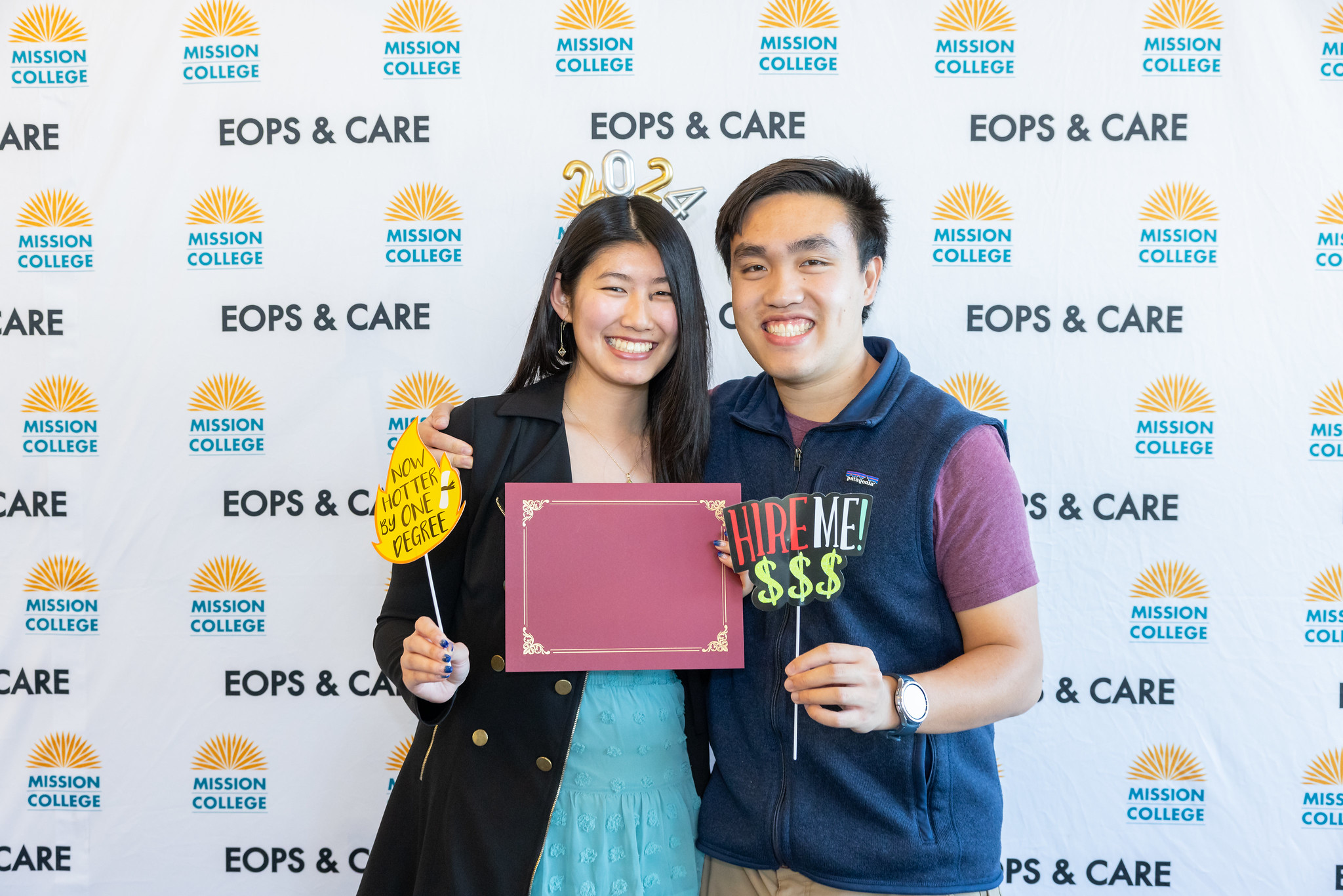 EOPS student posing for picture holding certificate folder