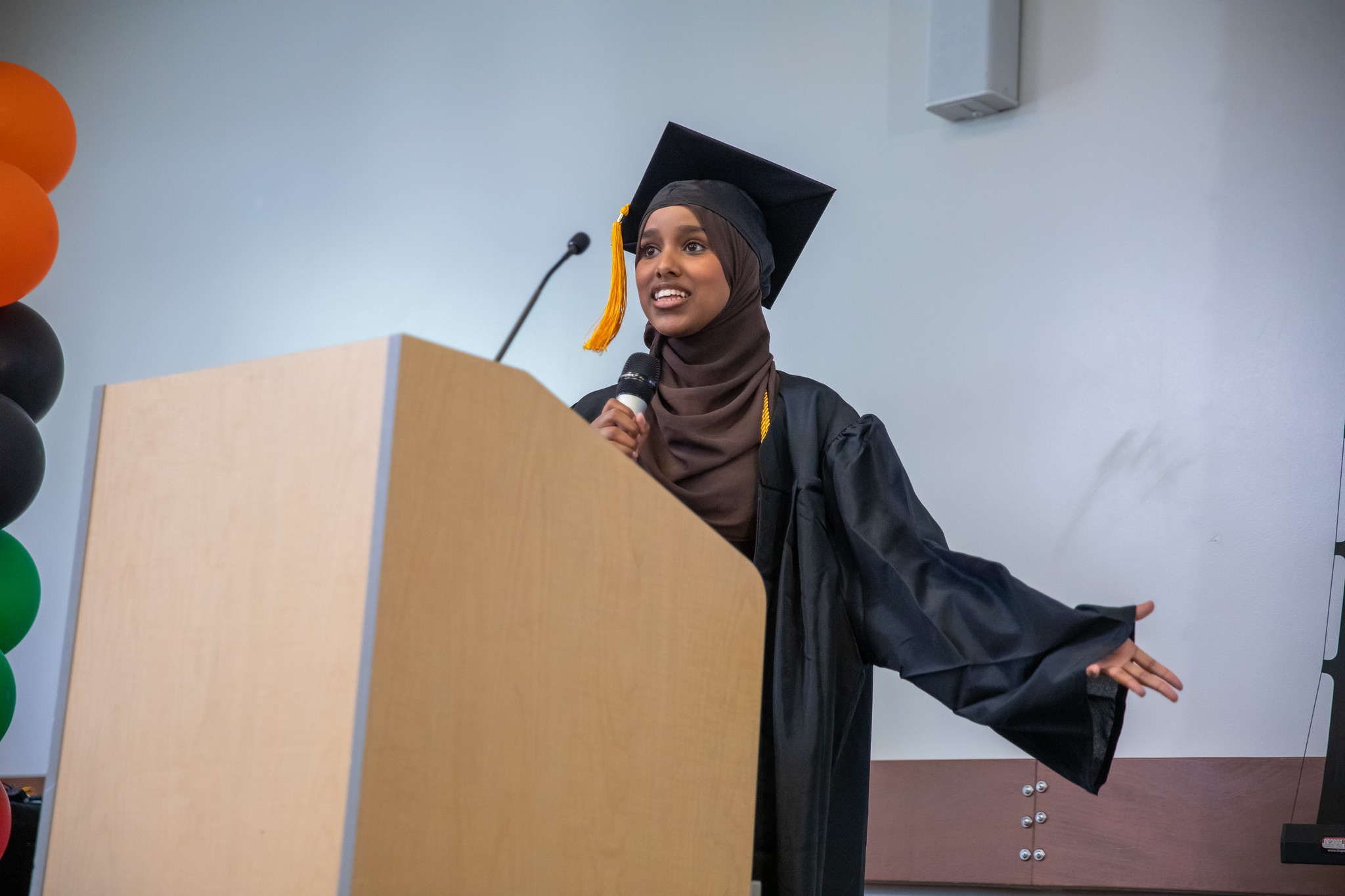 Umoja grad speaking at podium
