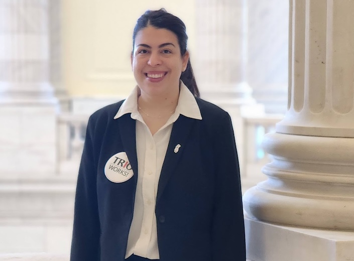 Priscila de Franca Moreira in a suit with a TRIO Works button on her chest.